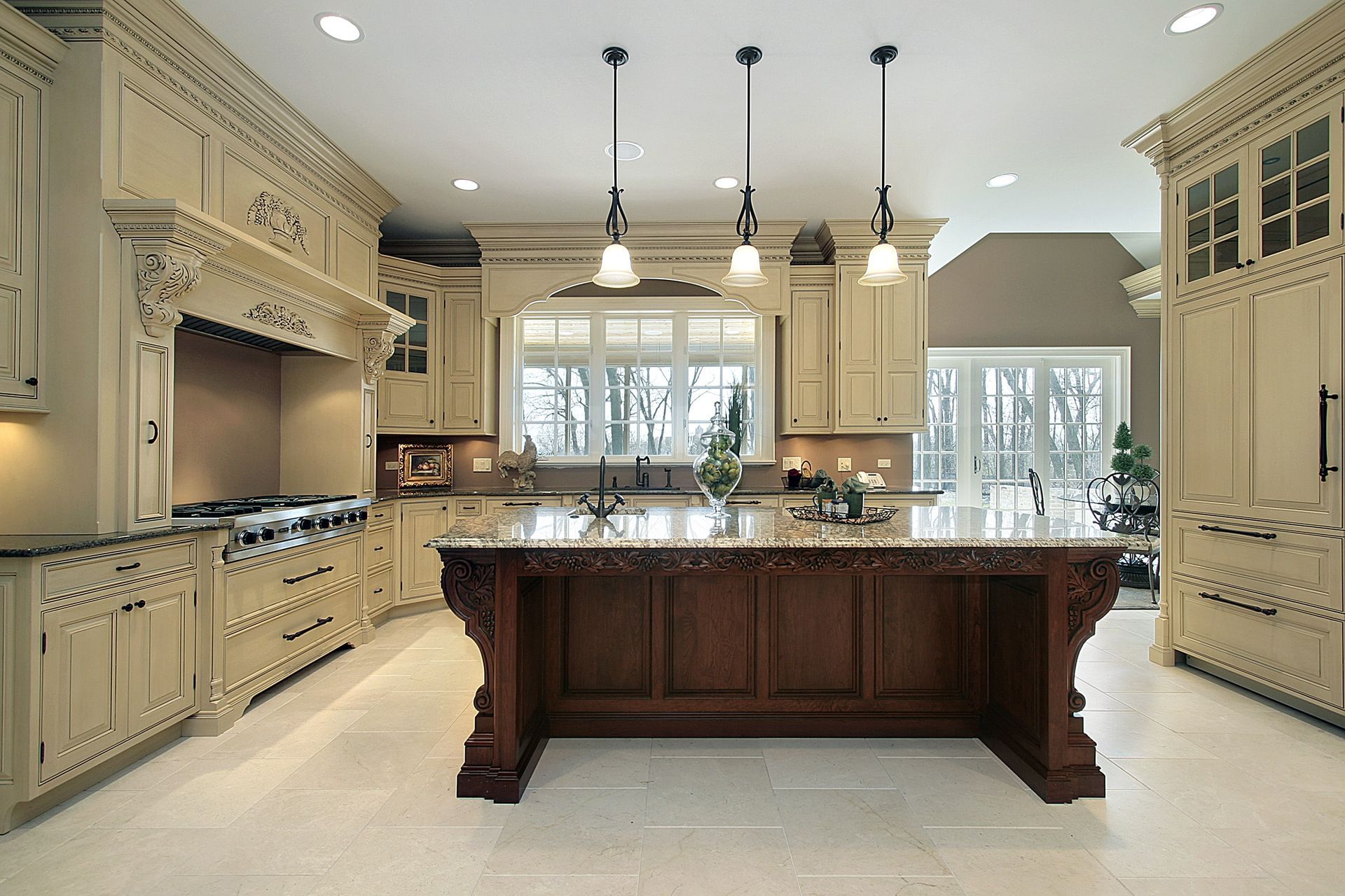 Elegant kitchen with cream cabinets, dark wood island, and pendant lights.