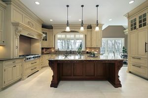 Elegant kitchen with cream cabinets, dark wood island, and pendant lights.