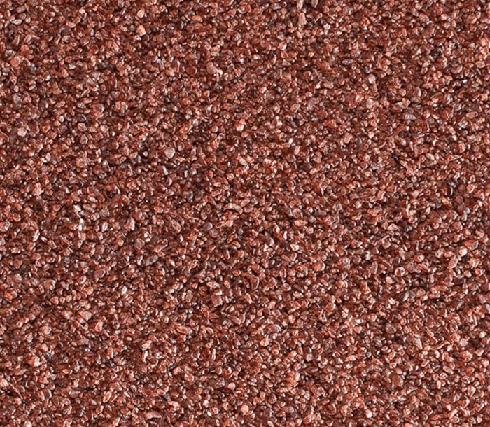 Vista ravvicinata di un aggregato grossolano di colore rosso-marrone, probabilmente utilizzato come abrasivo o in edilizia.