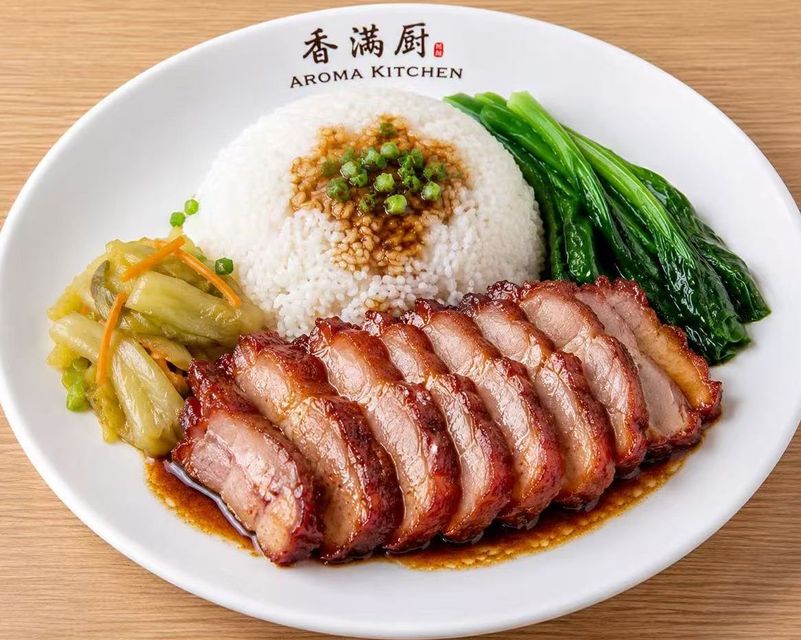 Plate of sliced roasted meat with rice, greens, and pickled vegetables on a white dish