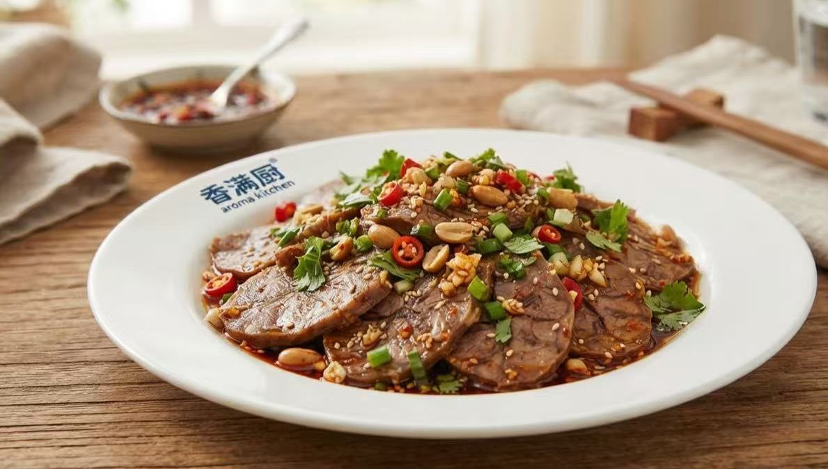 Plated sliced beef in spicy sauce topped with chopped chilies and herbs on a white dish