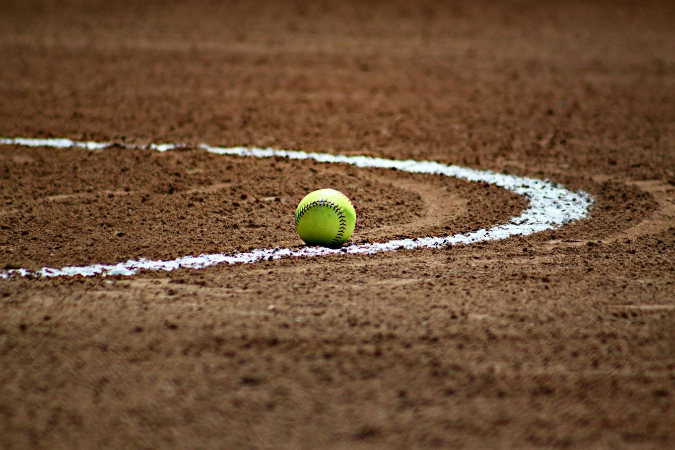 Baseball on a dark surface, with visible stitching.