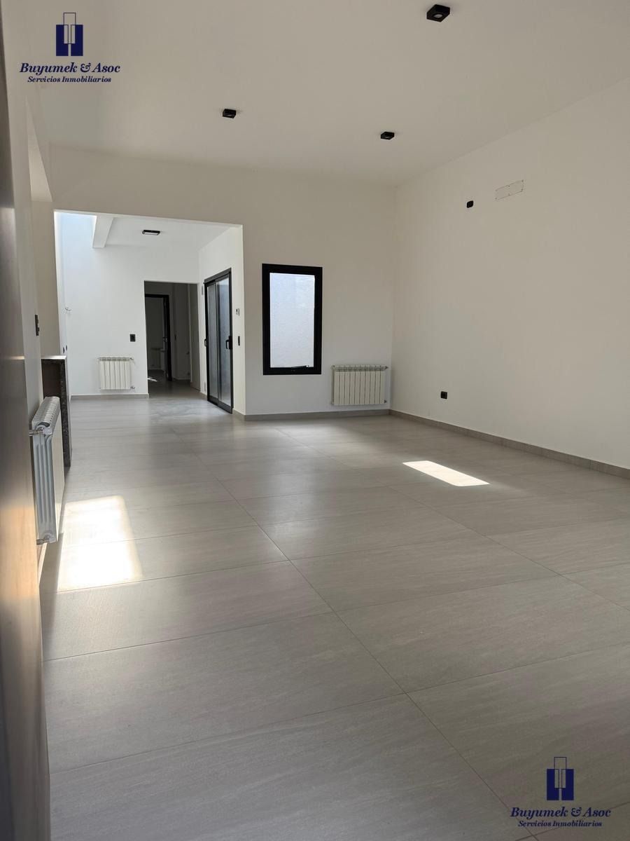 Casa moderna de color gris con un camino escalonado de hormigón que conduce a la entrada bajo un nivel superior en voladizo.