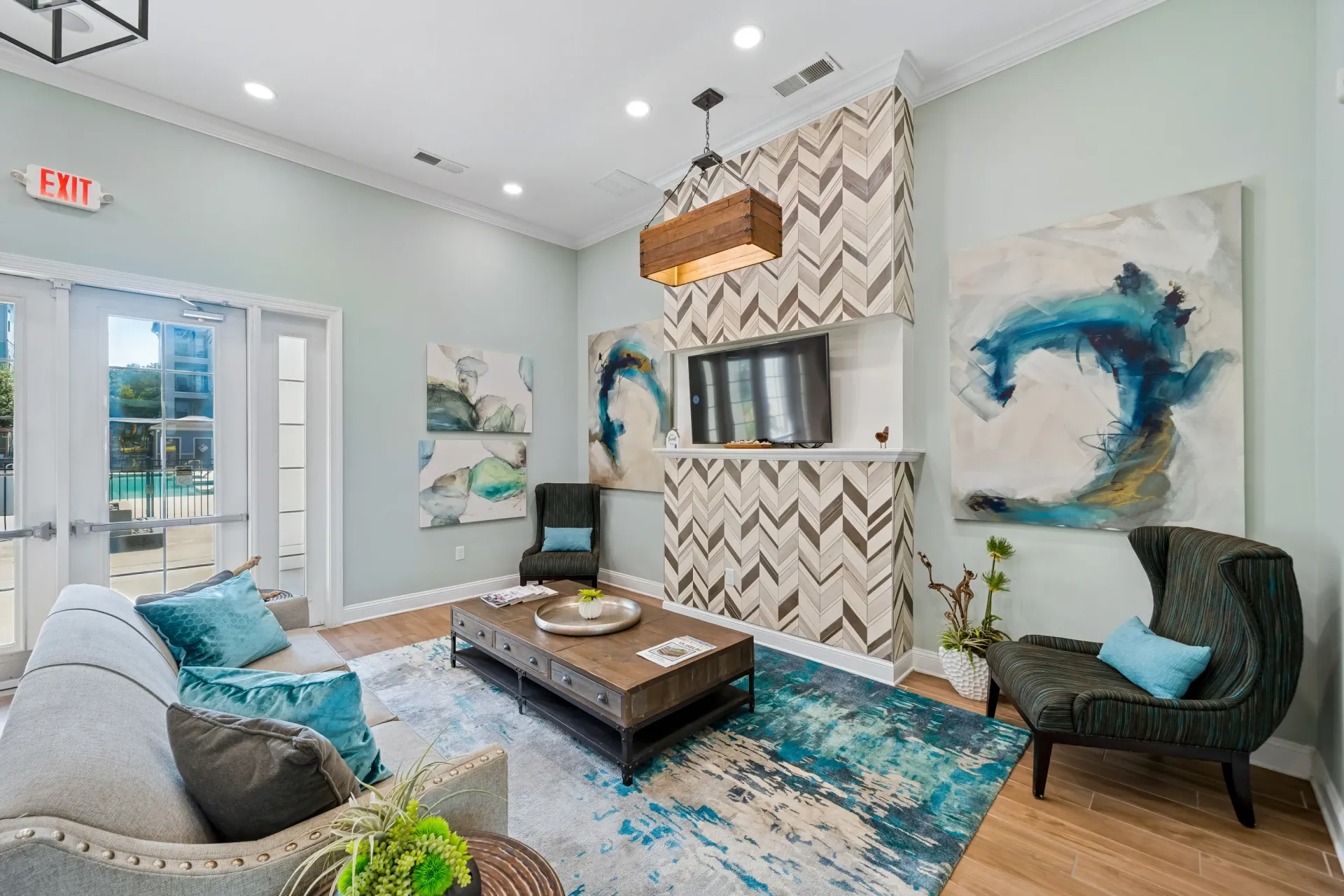 Modern living room with fireplace, large windows, and abstract art at Atlantic on the Avenue in North Charleston, SC.