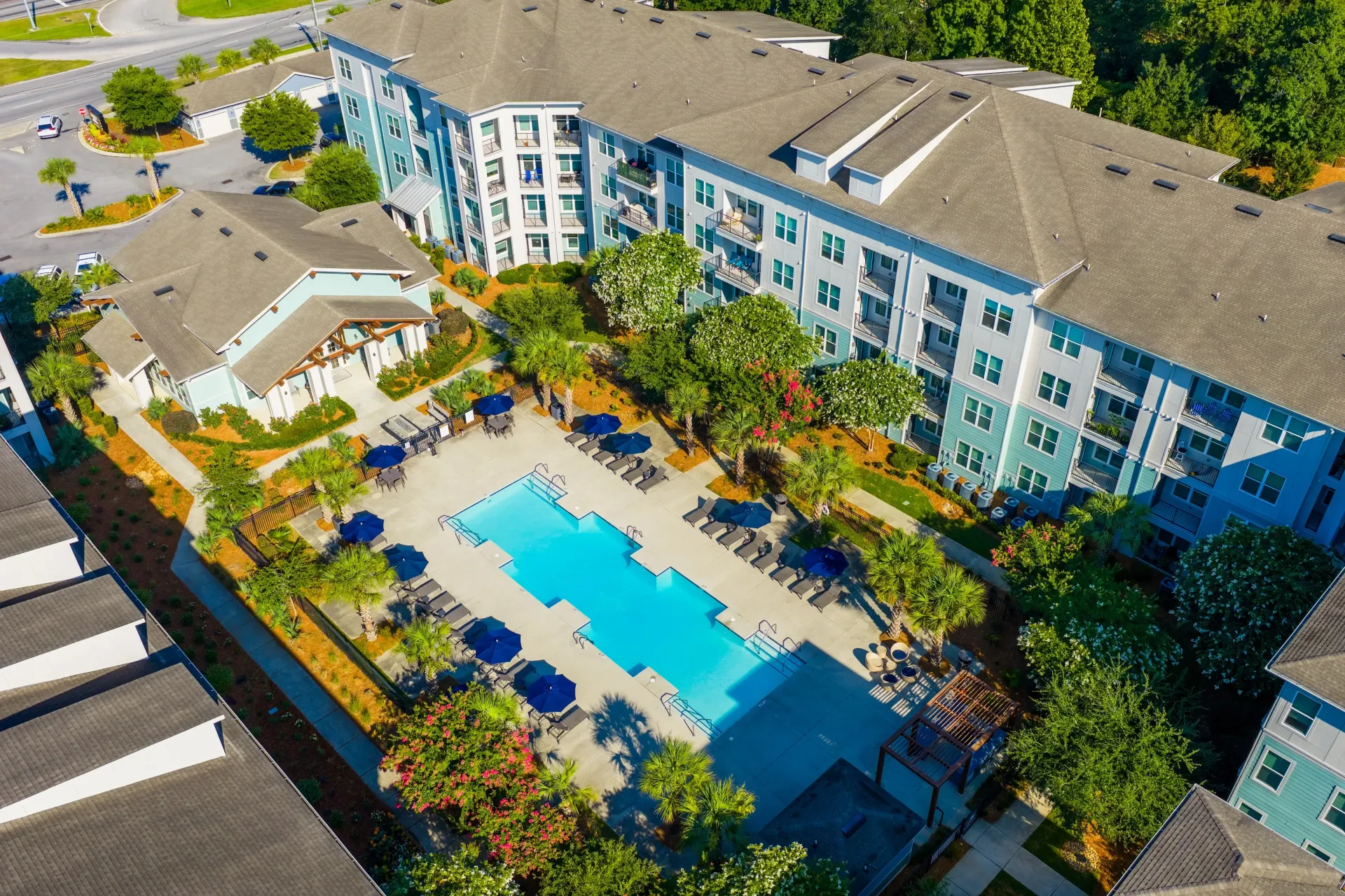 Aerial view of a resort-style swimming pool and surrounding apartment buildings at Atlantic on the Avenue in North Charleston, SC.