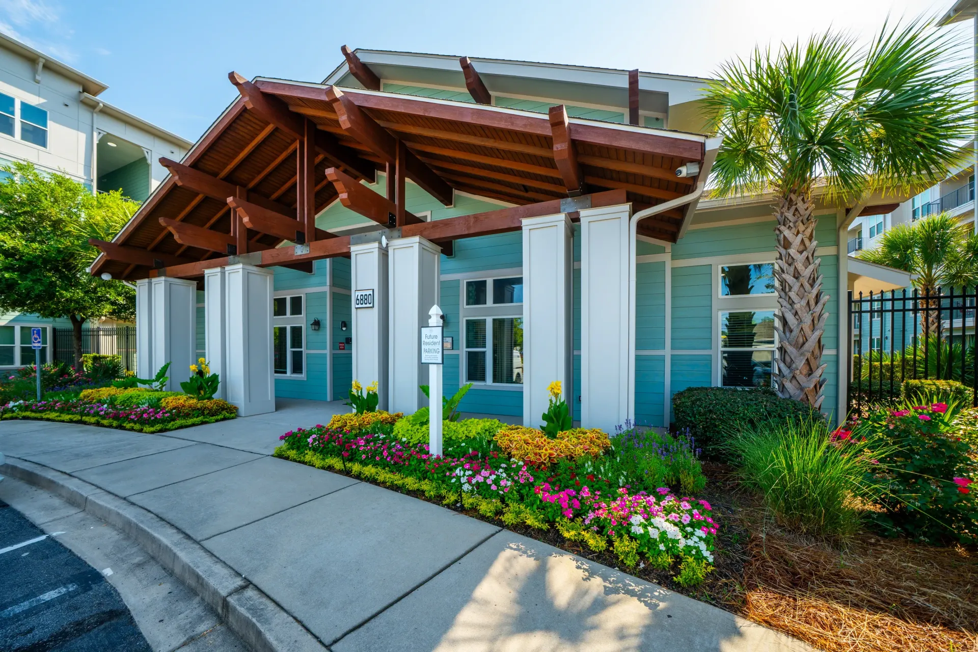 Building entrance with a modern architectural design featuring a wooden overhang and bright blue siding at Atlantic on the Avenue in North Charleston, SC.