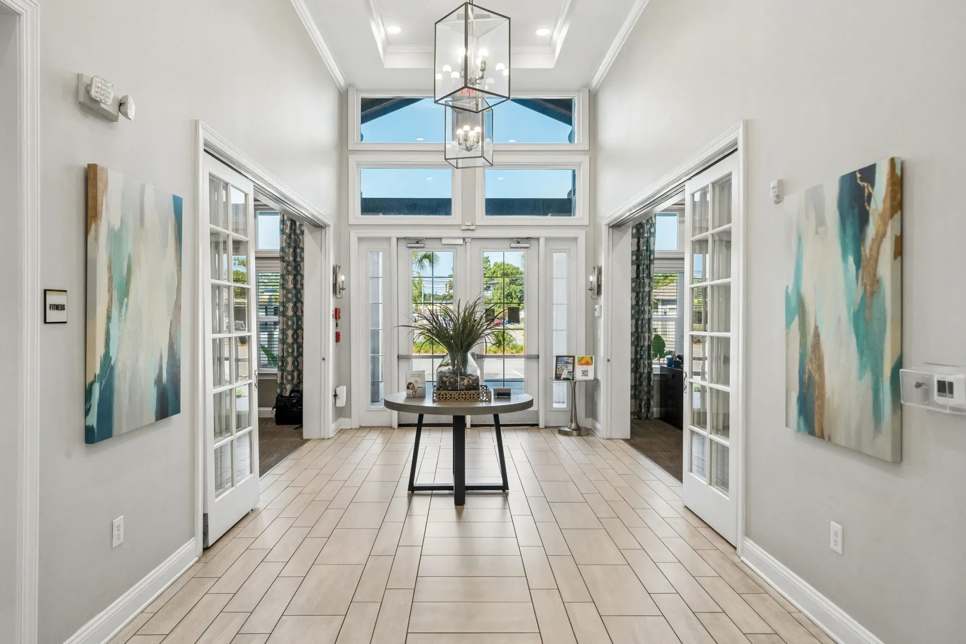 Bright and airy lobby with double doors, large windows, and modern decor at Atlantic on the Avenue in North Charleston, SC.