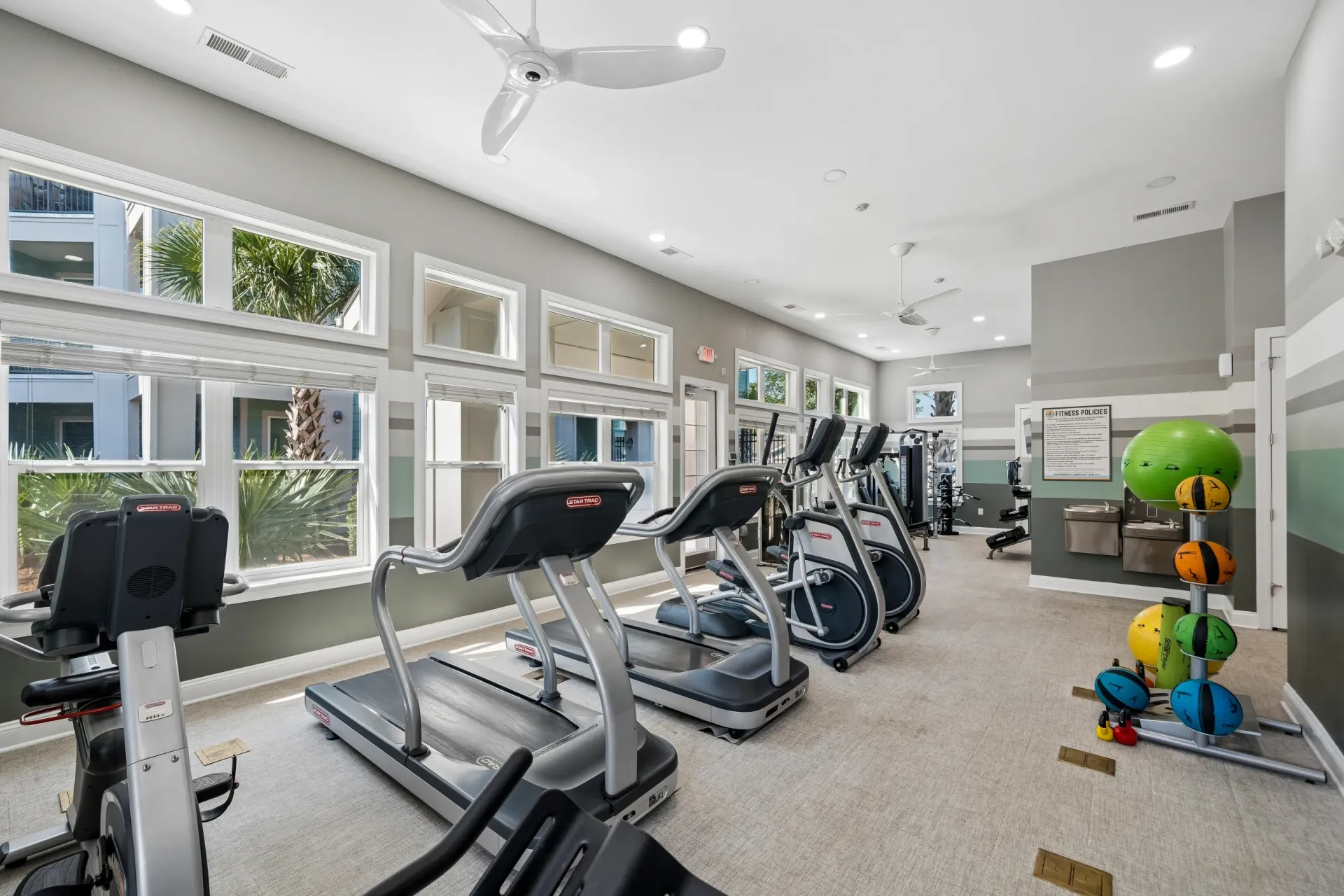 Fitness center with treadmills, ellipticals, weight machines, and exercise balls at Atlantic on the Avenue in North Charleston, SC.