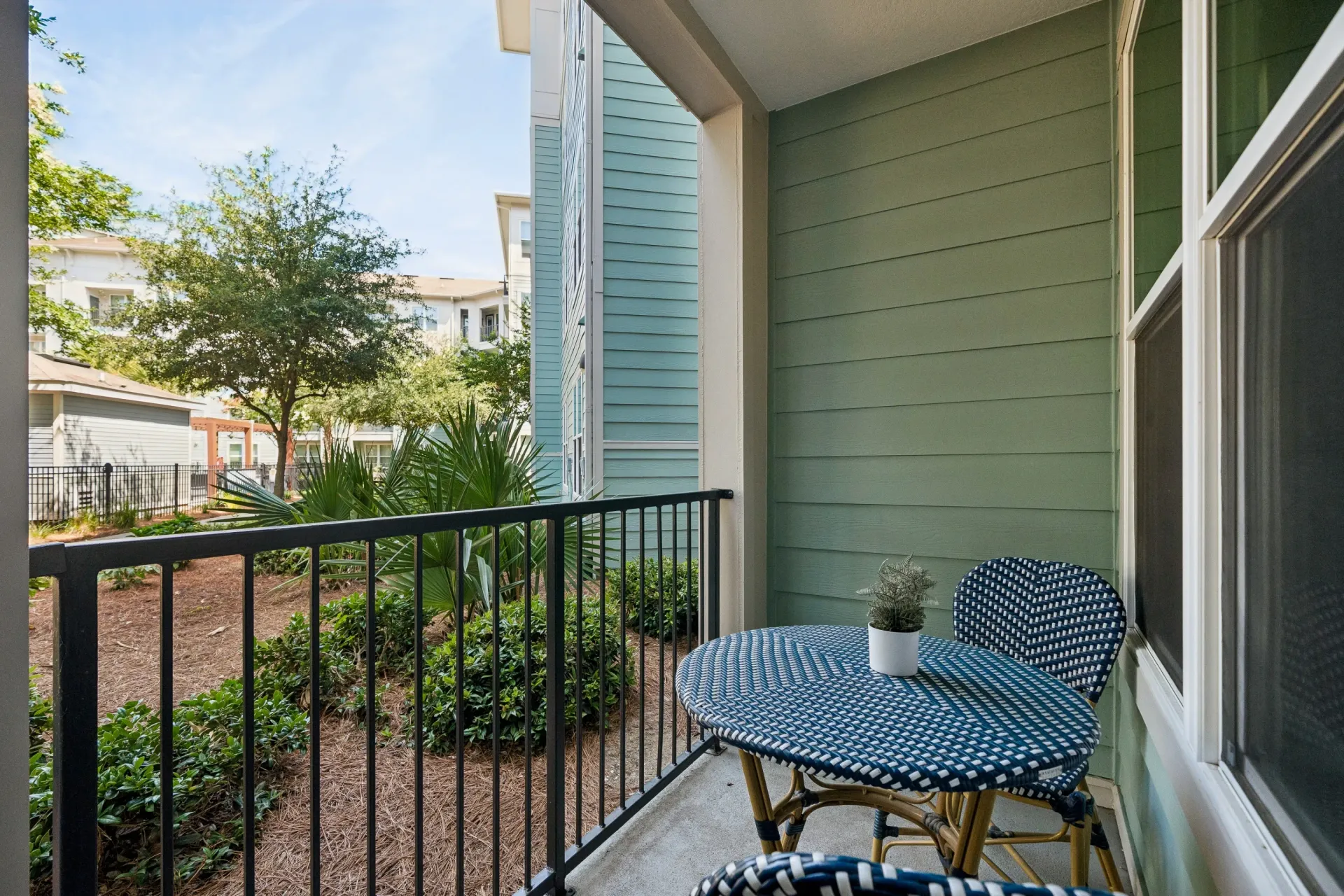 Balcony with a bistro set overlooking a courtyard at Atlantic on the Avenue in North Charleston, SC.