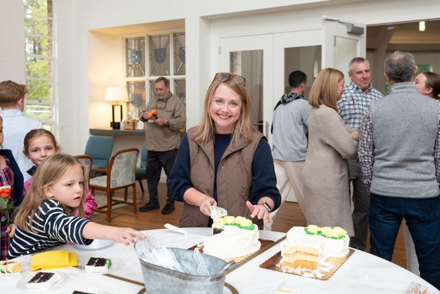 People gathered around a table with dessert at a casual indoor gathering
