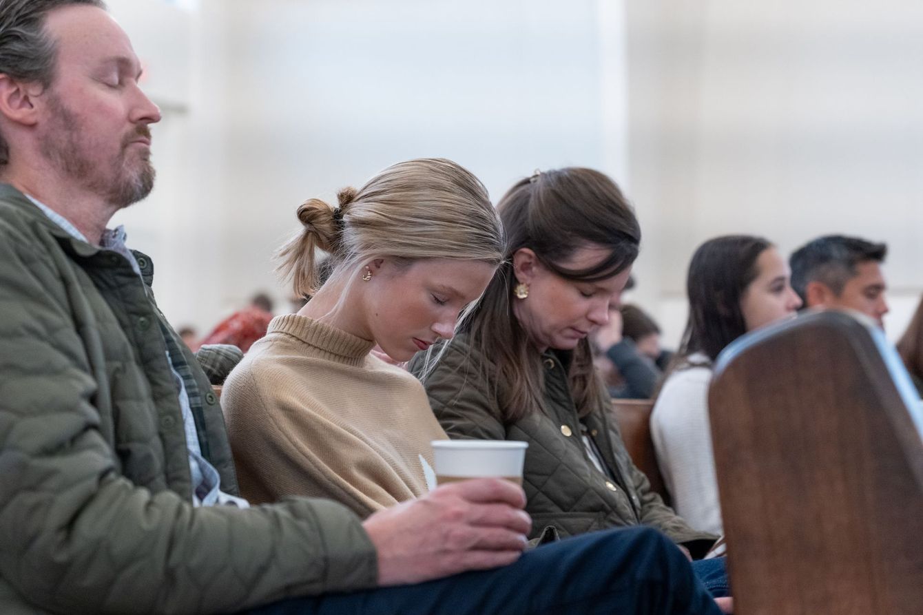 People seated and praying during worship