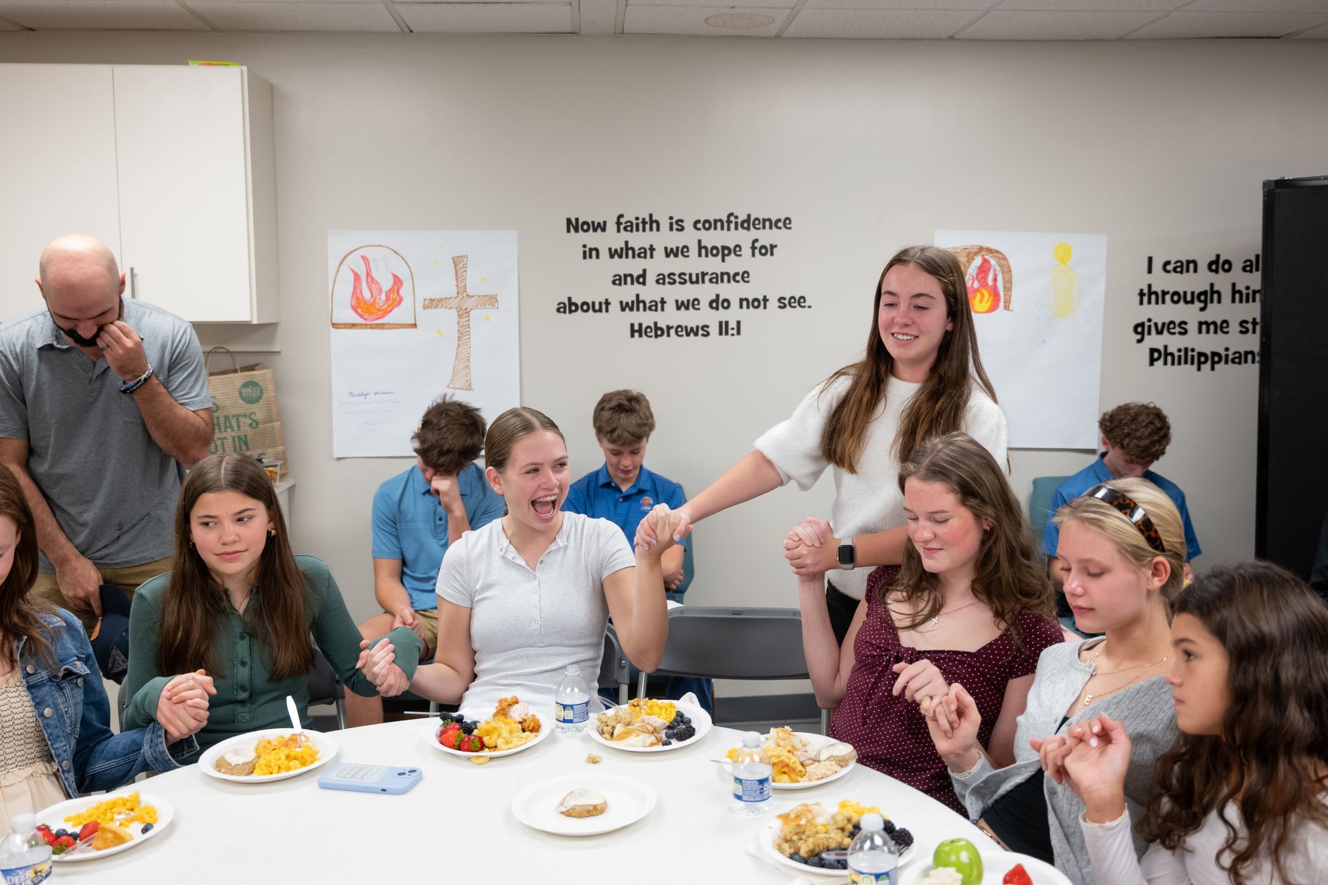 People seated around a table sharing food at a casual indoor gathering