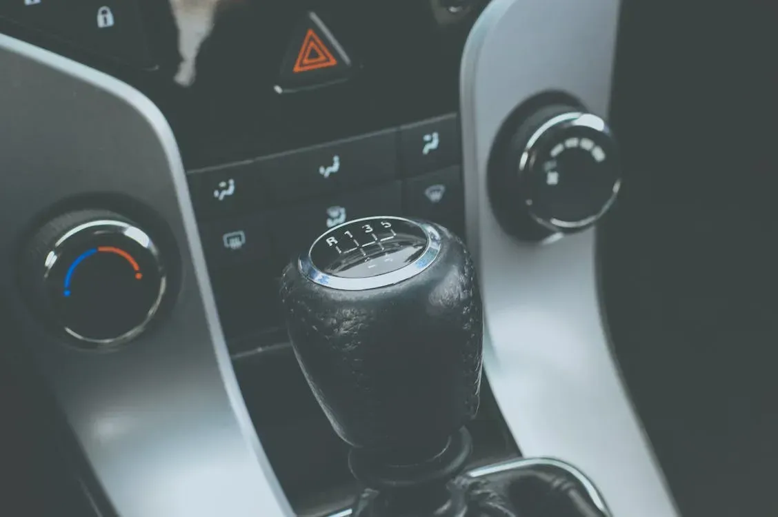 Car gear shift and climate control panel with hazard light button in a gray interior