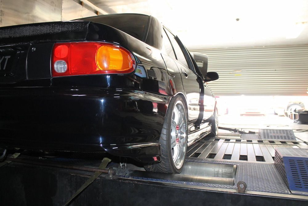 A Black Car Is Sitting On A Ramp In A Garage — Dynolink In Garbutt, QLD