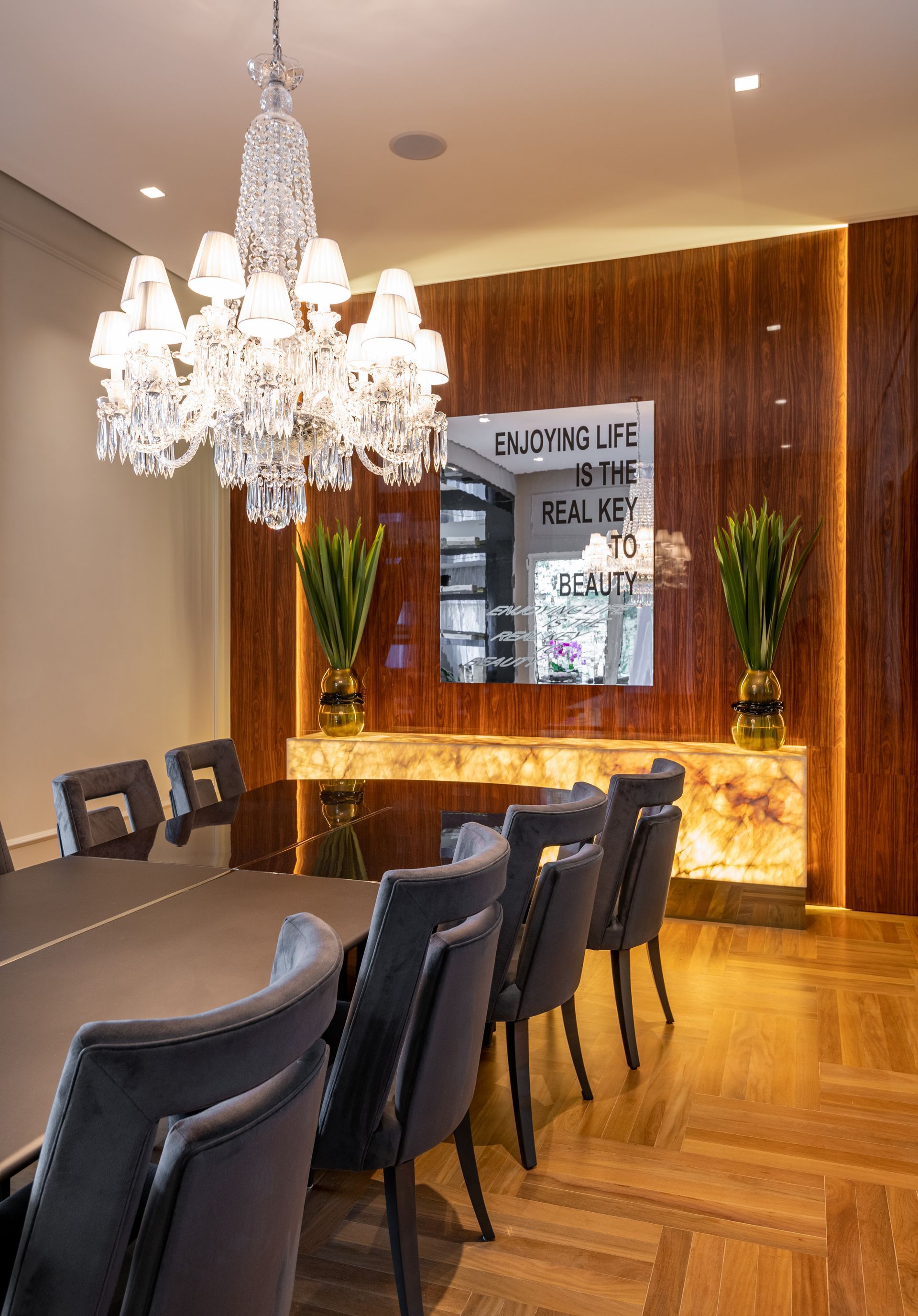 Uma sala de jantar com uma mesa e cadeiras e um lustre pendurado no teto.