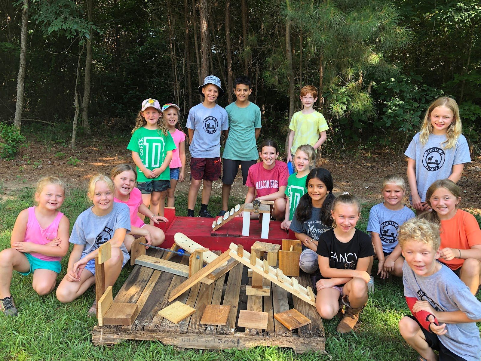 A group of children are posing for a picture in front of a wooden structure.