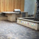 There is a table and a grill in the backyard.