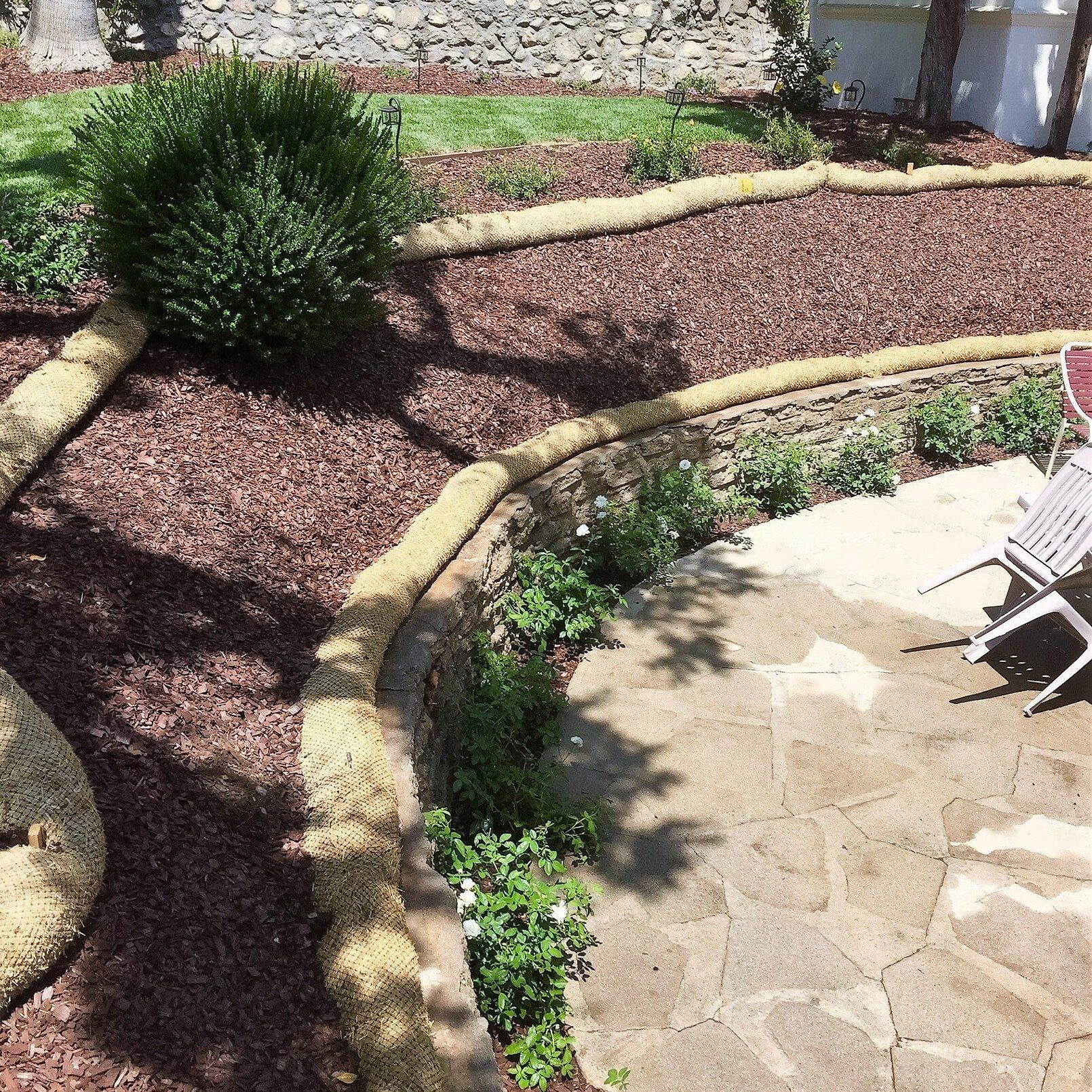A patio with a chair and a table in a garden.