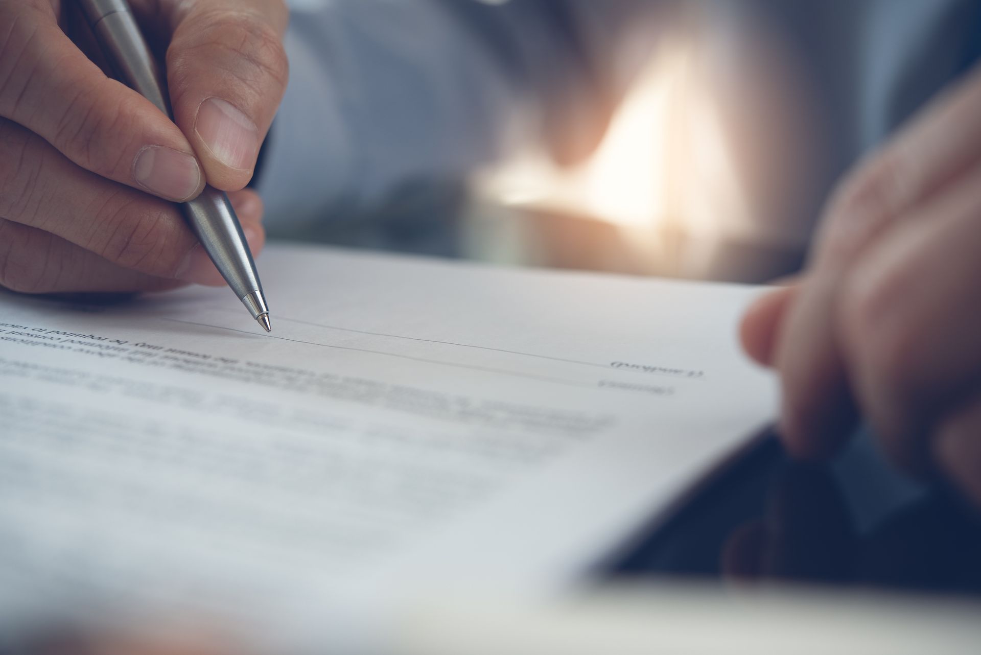 a man signing a document with a pen