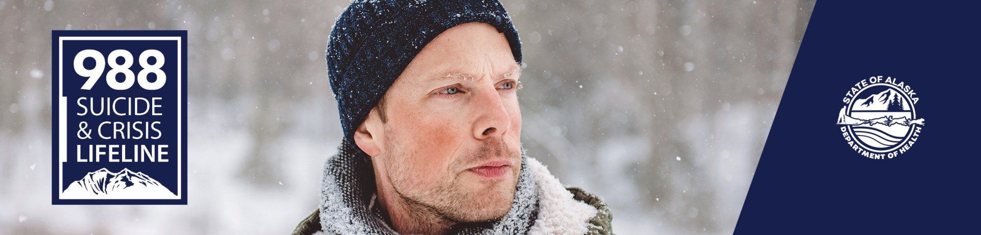 A person in a winter hat and scarf looks off-camera in the snow, next to a 988 Suicide & Crisis Lifeline logo.