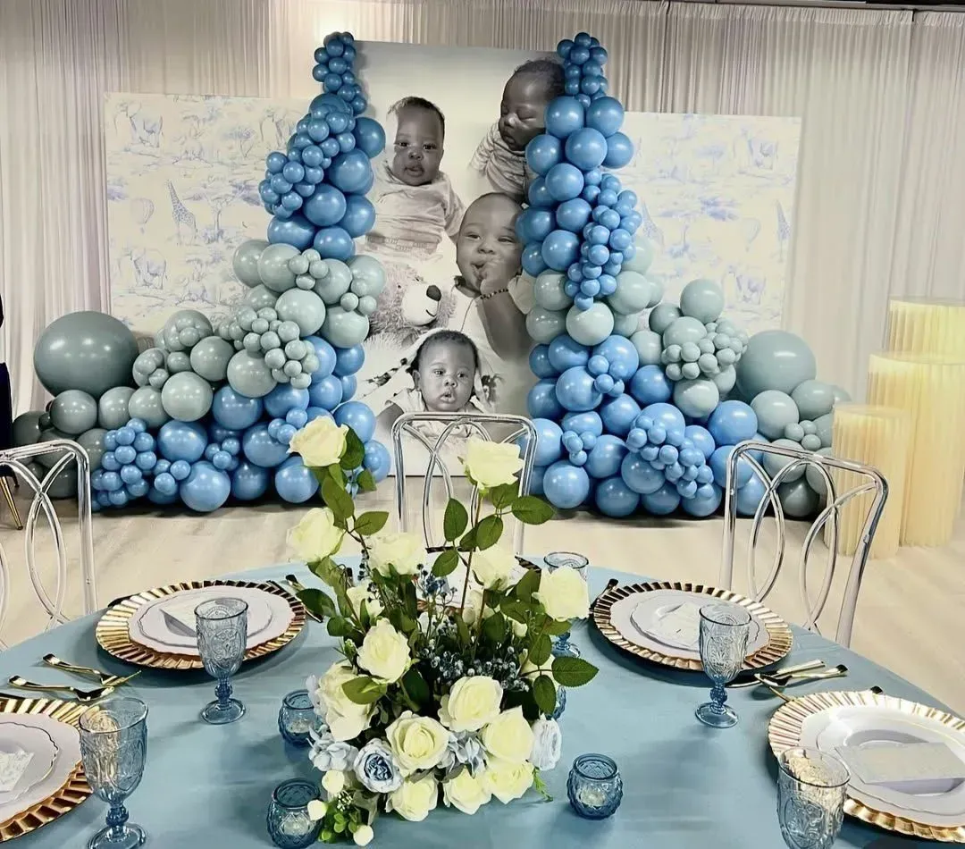Blue balloon backdrop with black-and-white portraits and a white-and-blue decorated dessert table