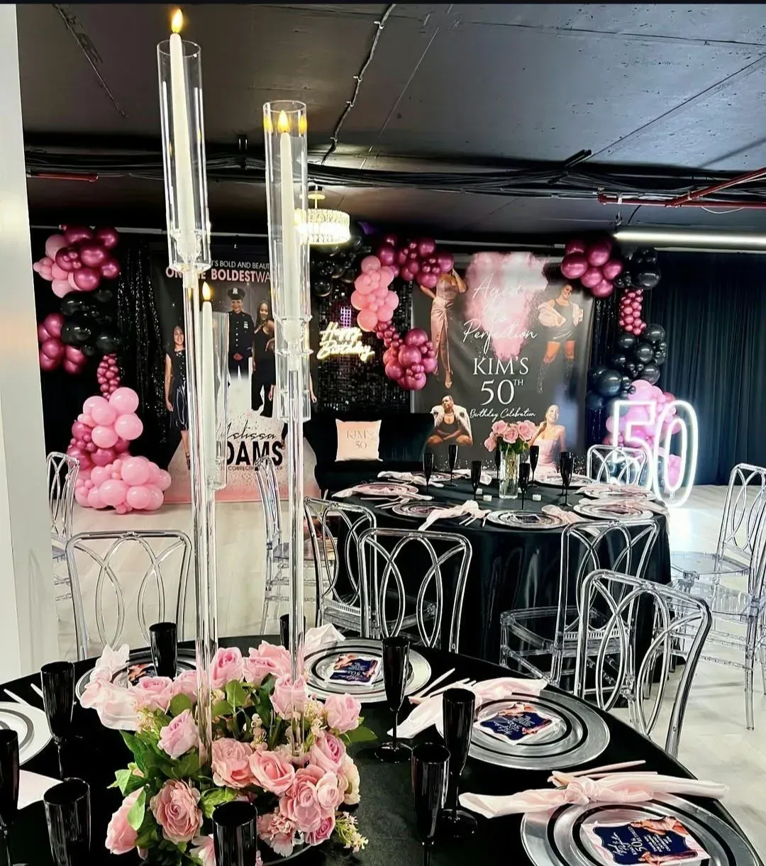 Elegant black-and-pink birthday party setup with balloons, candle centerpieces, and decorated tables