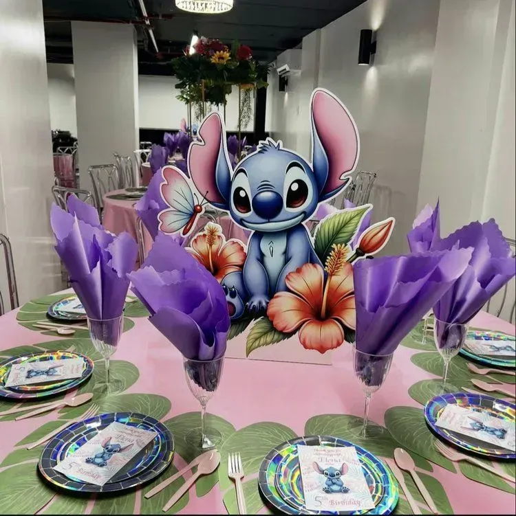 Stitch-themed party table with purple napkins, flower centerpiece, and colorful character plates
