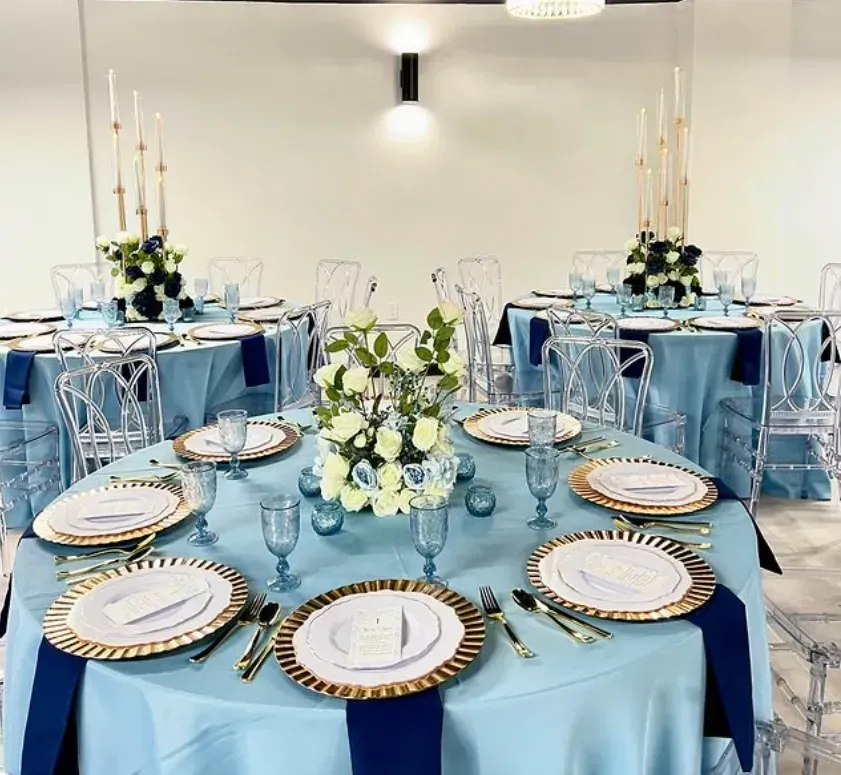 Elegant blue-and-white banquet tables set for an event with floral centerpieces