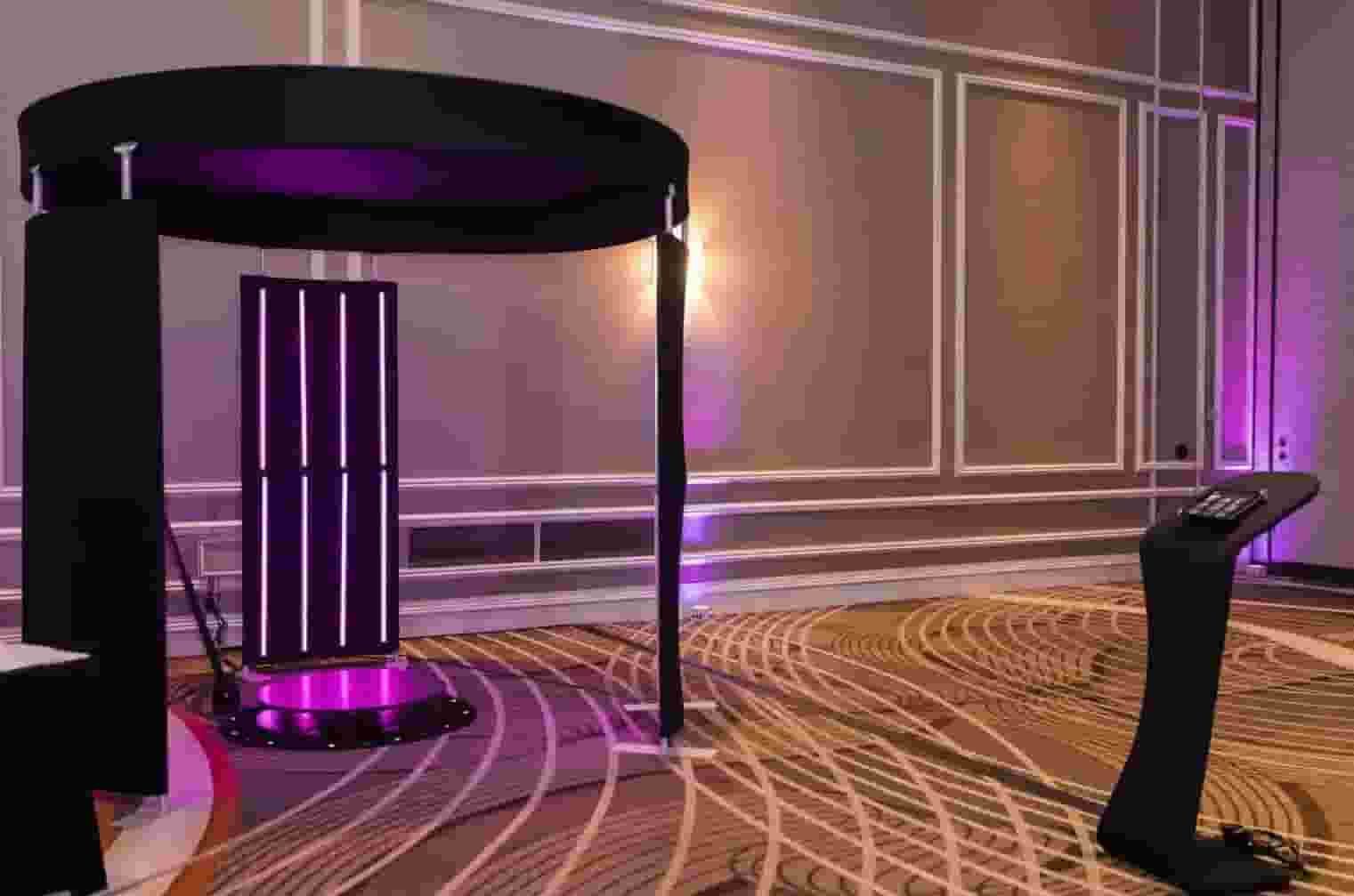 Purple-lit futuristic room with a large cylindrical structure and a curved black pedestal