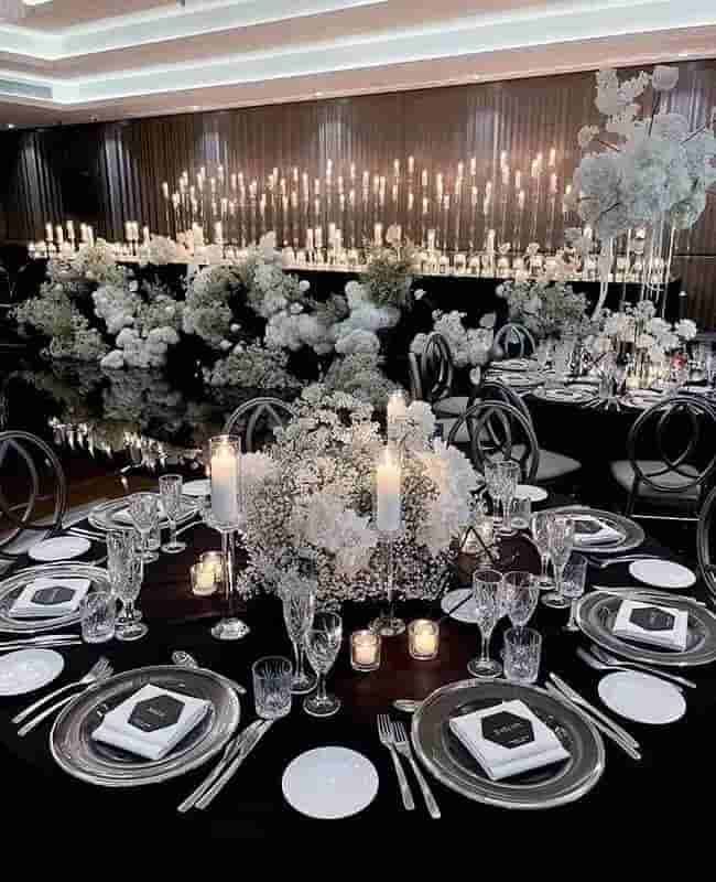 Elegant black-and-white banquet table with candles and white floral centerpieces