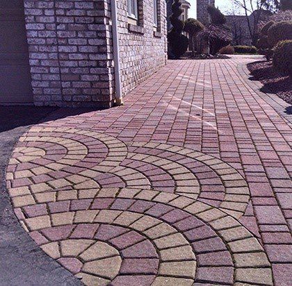 Brick walkway with circular pattern in varying shades of red and tan.