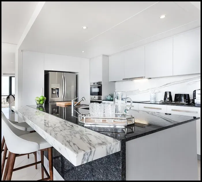 Modern commercial kitchen with polished marble benchtop and clean stone surfaces