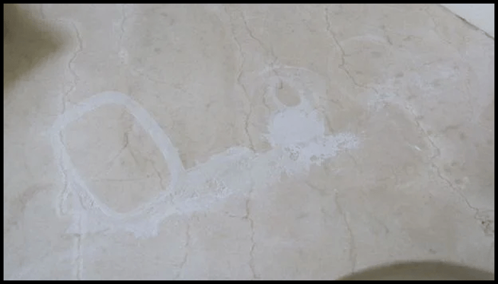 Etching and white stains on marble surface caused by acidic cleaner or hard water