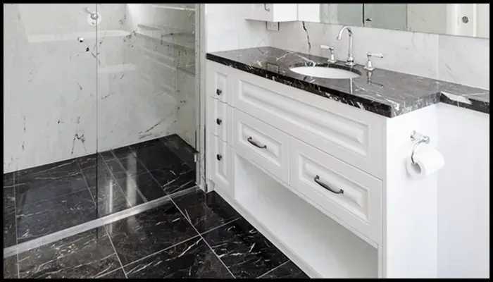 A polished black marble bathroom benchtop and floor, demonstrating the benefits of proper care and maintenance.