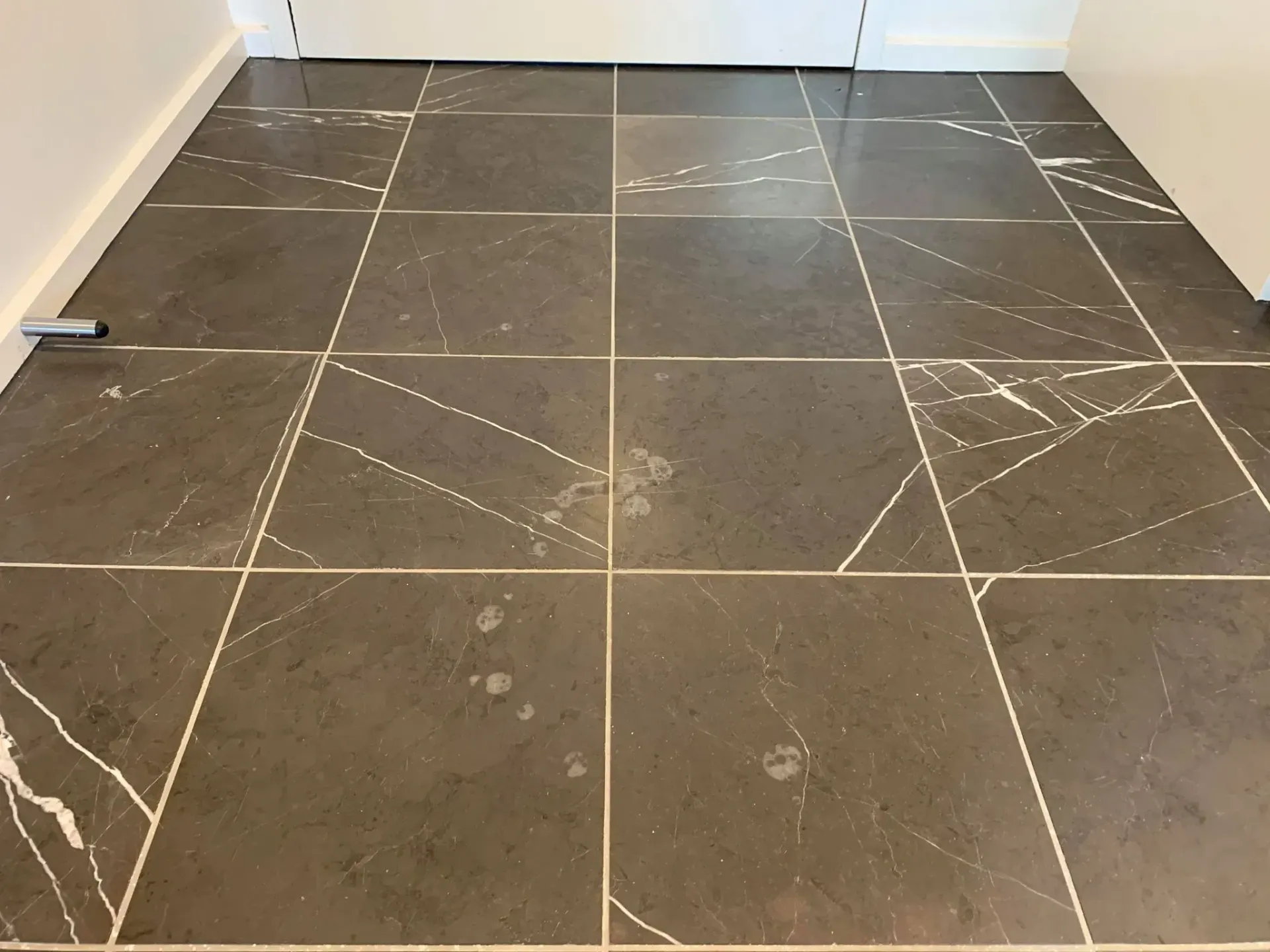 A black tile floor with white lines on it