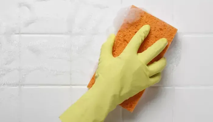Scrubbing tiles with a sponge
