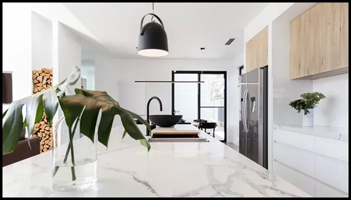 A modern kitchen with a white marble benchtop, showcasing its elegance and need for proper care.