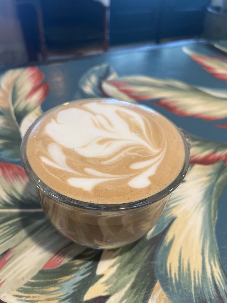 A close up of a cup of cappuccino on a table.