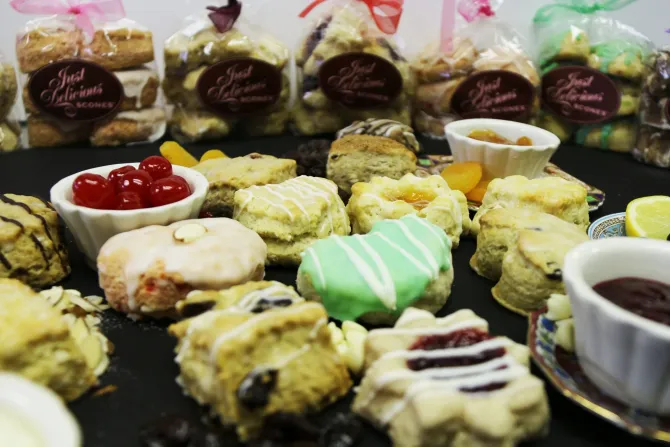 A table topped with a variety of pastries including scones and cookies.