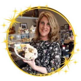 A woman is holding a plate of cookies in her hand.