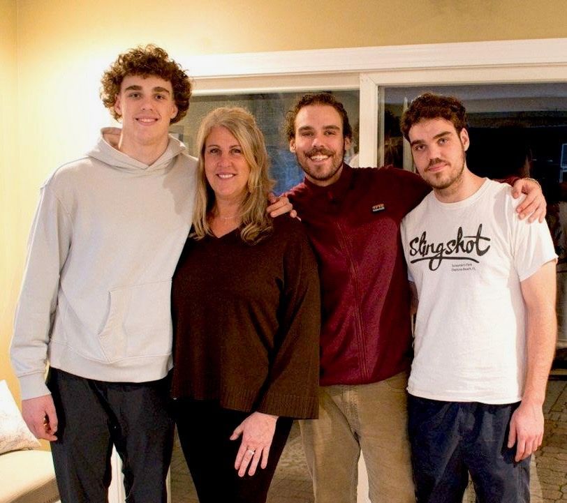 A group of people posing for a picture with one wearing a slingshot shirt