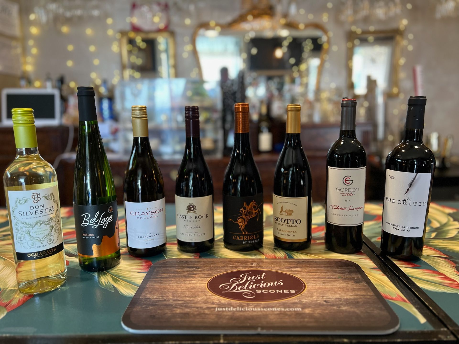 A variety of wine bottles are lined up on a table.