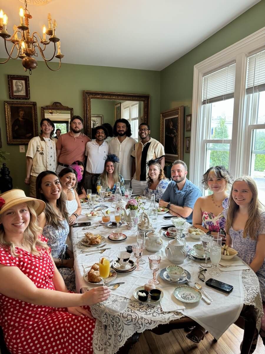 A group of people are sitting at a long table with food.