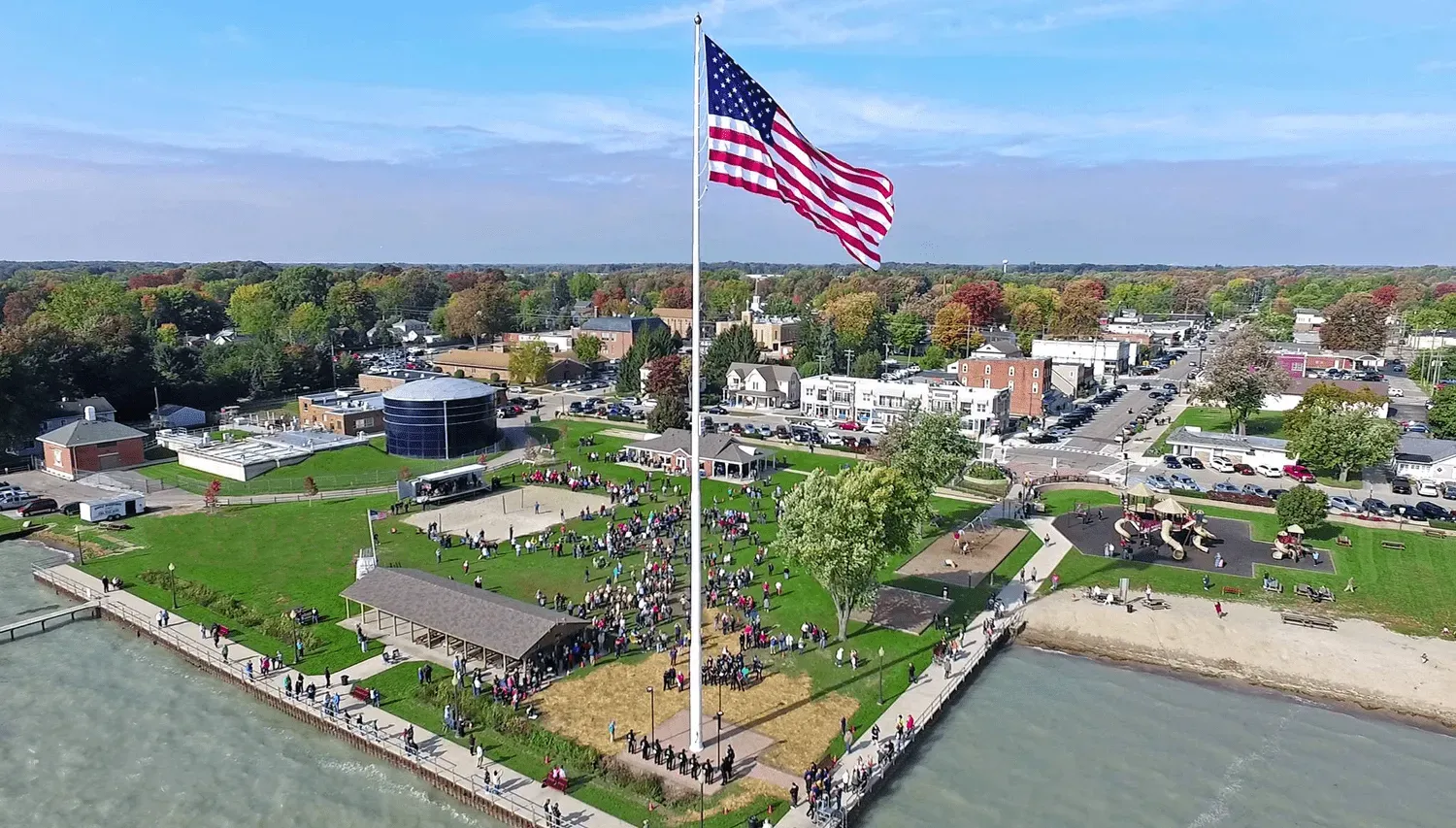 An aerial view of a large american flag flying in a park.