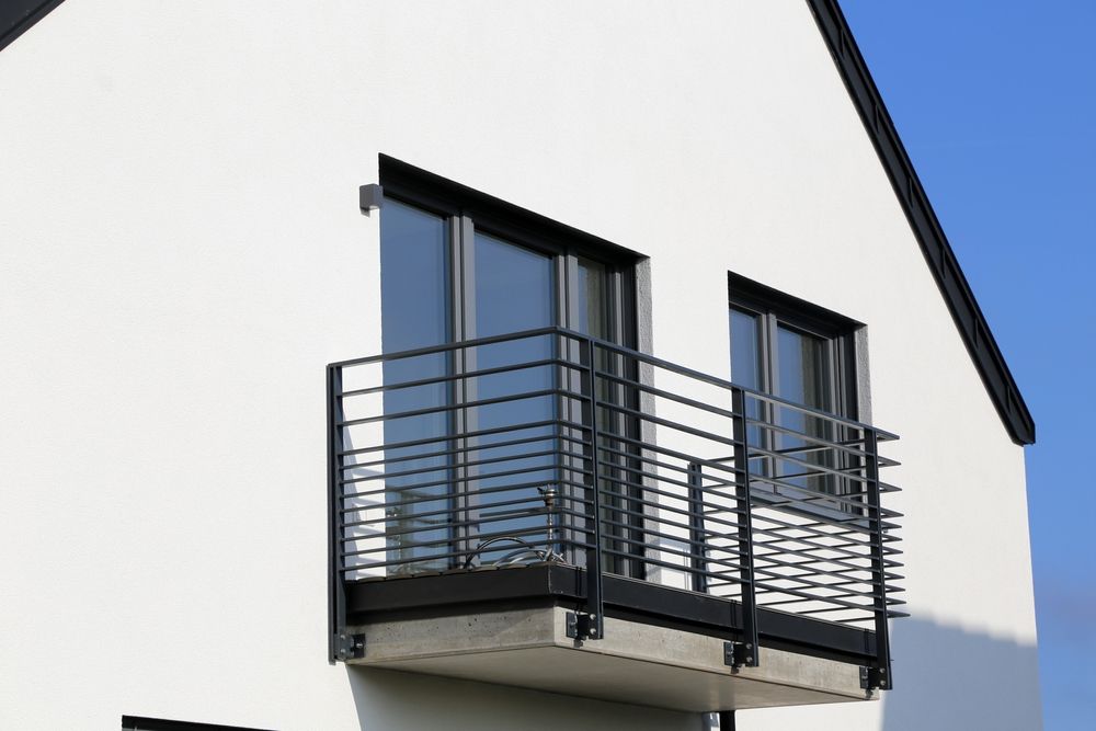 A white house with a balcony and a black railing — Febos Welding and Engineering In Corrimal, NSW