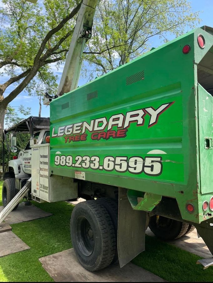 Legendary Tree Care LLC | green and white truck with the word legendary on the side is parked in front of a tree.