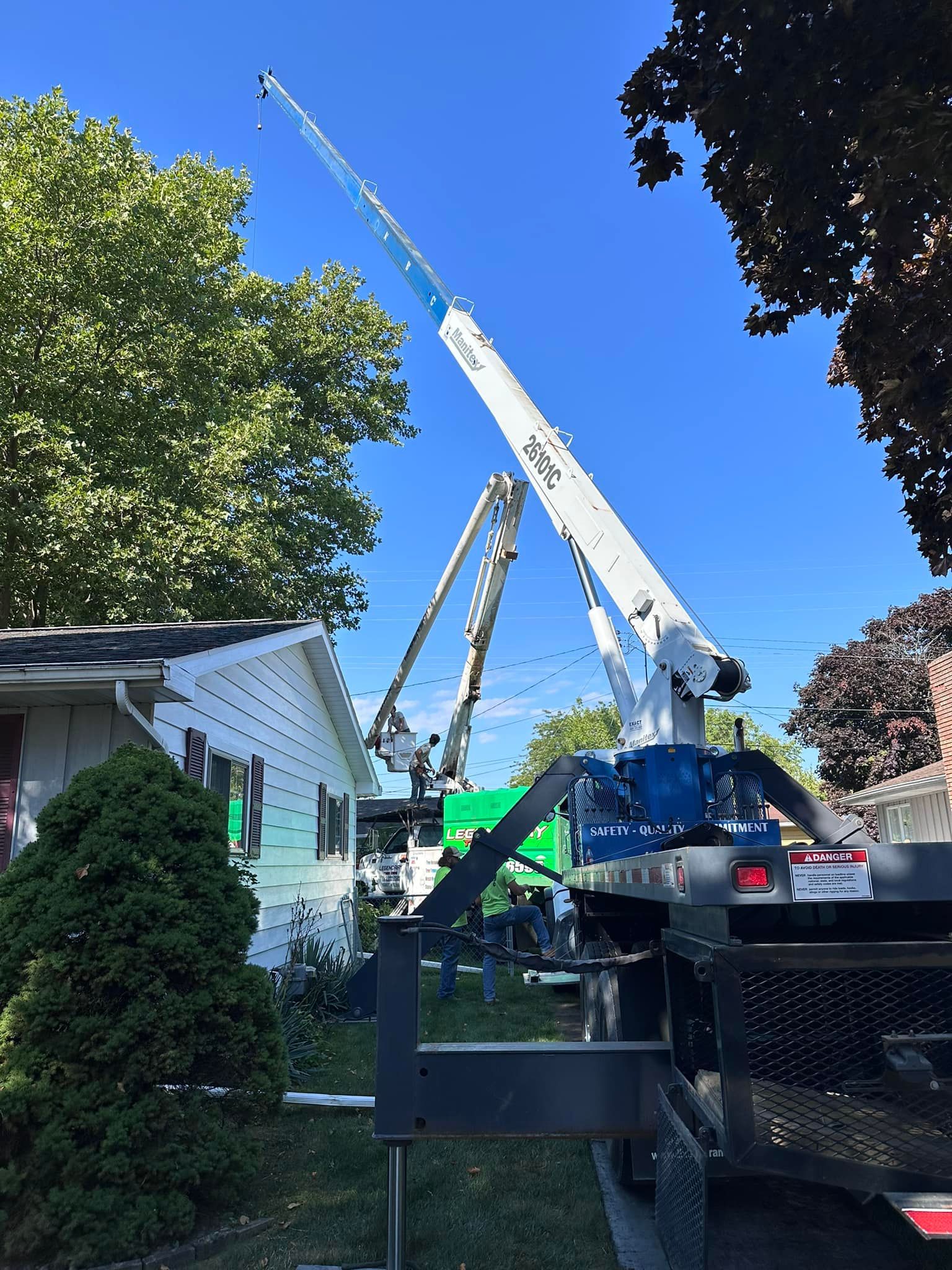 Legendary Tree Care LLC | large crane is sitting in front of a house.