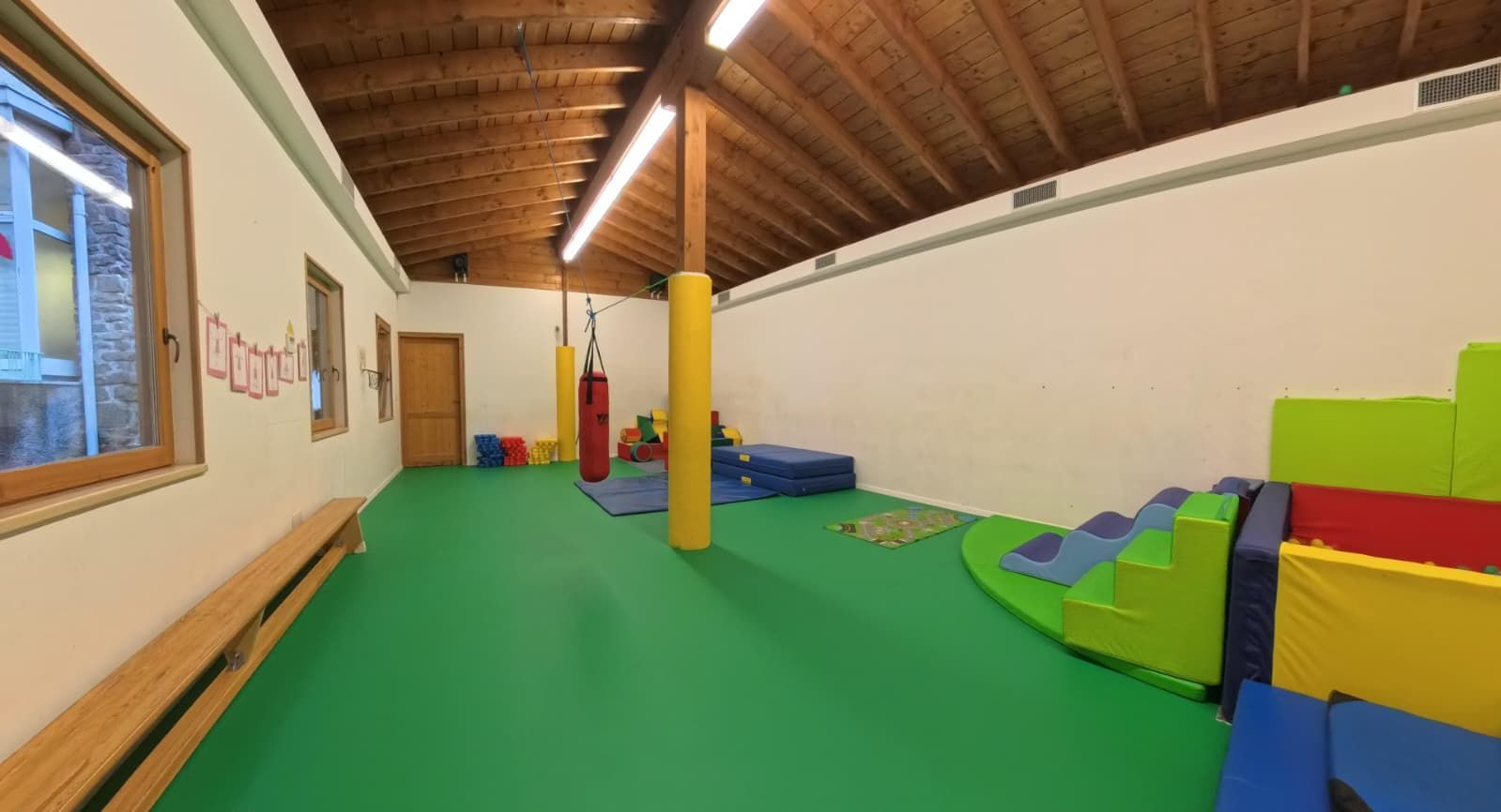 Corridoio con porte aperte, pareti e pavimento chiari, che conduce ad altre stanze.