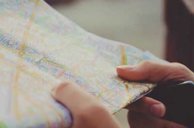A person is holding a map in their hands and looking at it.