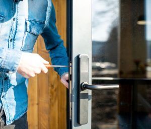 A man is fixing a door with a screwdriver.